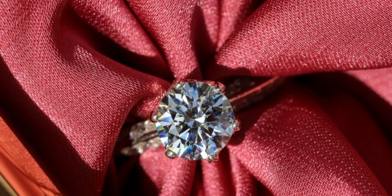silver diamond ring on red textile
